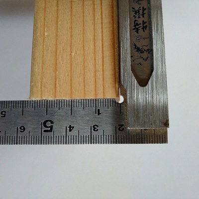 直角切り後、切断面にスコヤを当て直角にきれているか確認している様子（側面）