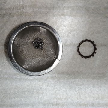 左：茶こしにベアリングのボールを入れた様子（洗浄済み）　右：洗浄したリング